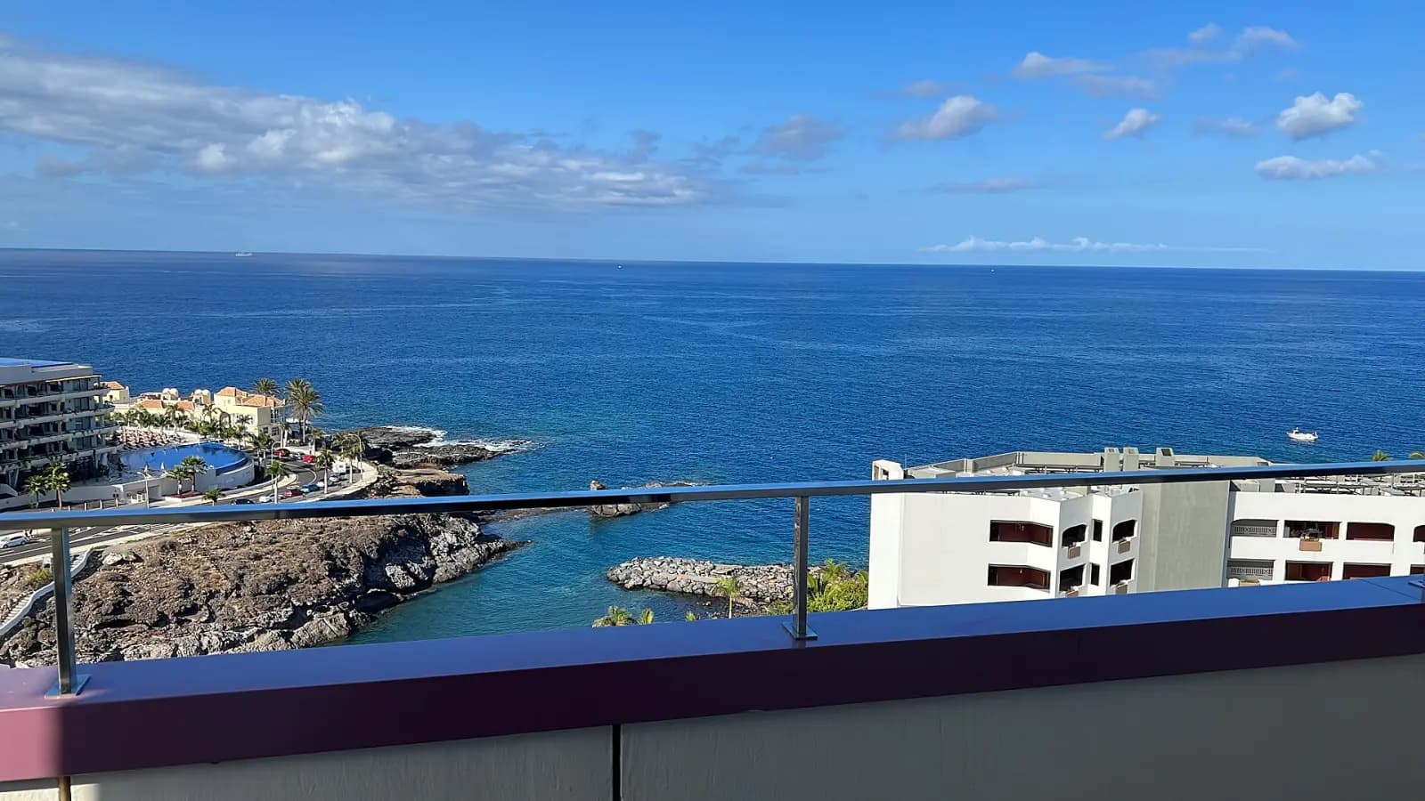 Balkon korkuluğunun ardında uzanan açık deniz manzarası