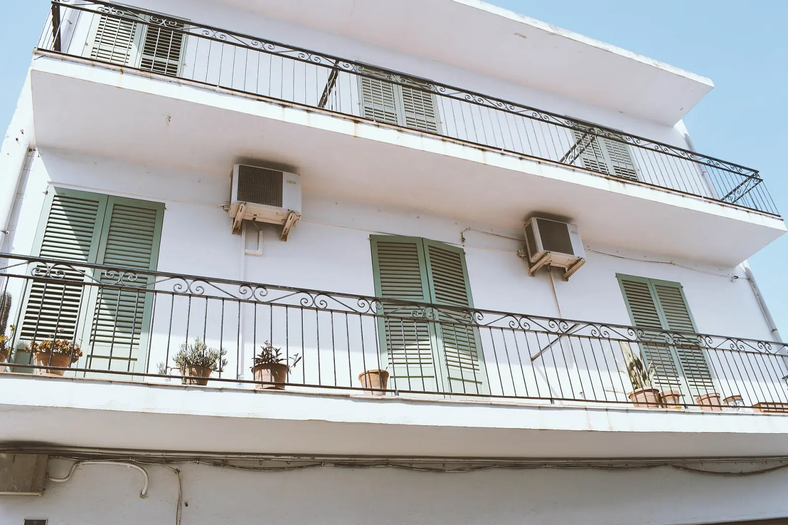 Ferforje balkonlu, panjurlu beyaz apartman cephesi